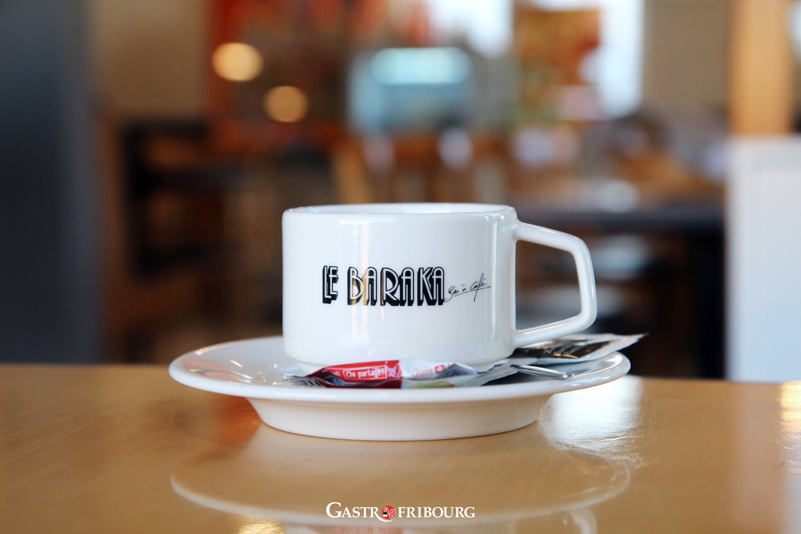 Une tasse « Le Baraka » sur sa soucoupe, posée sur une table de la salle